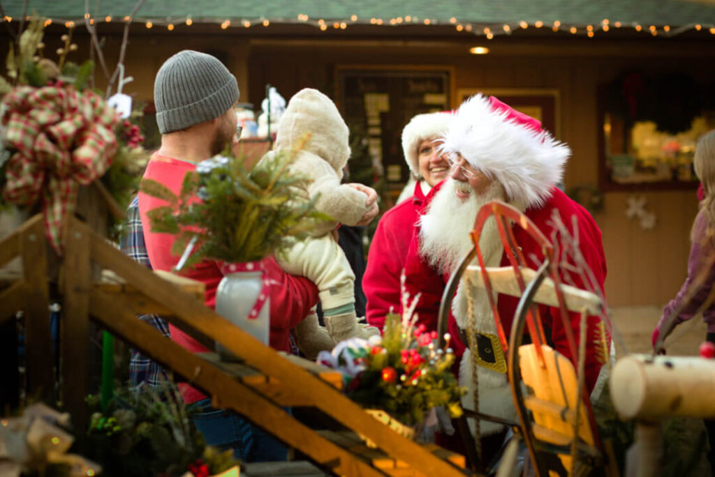 Santa talking with a toddler in his dads arms